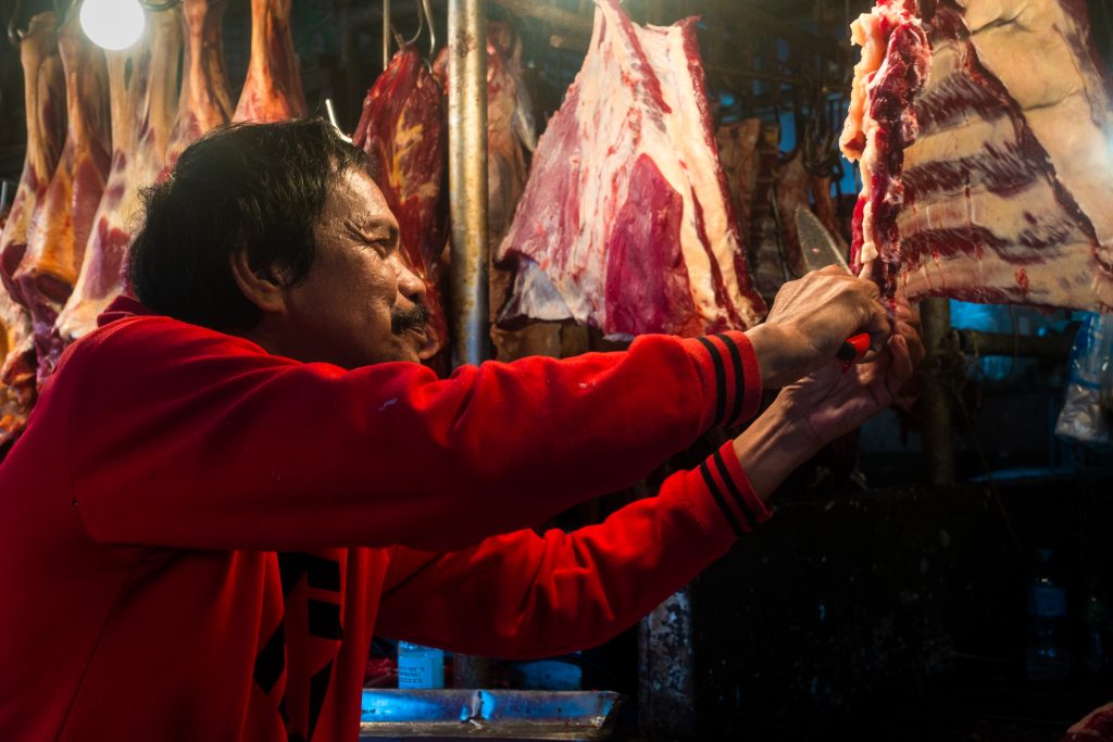 Man cutting meat. Meat market. Mahogany Ave., Tagaytay City. 2019 February 14.