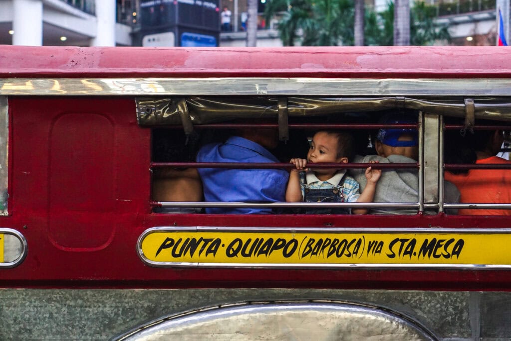 A child looks out of a passenger Jeepney, noticeably not in their designated route, plying Pedro Gil St., Ermita, Manila. 9 July 2017.