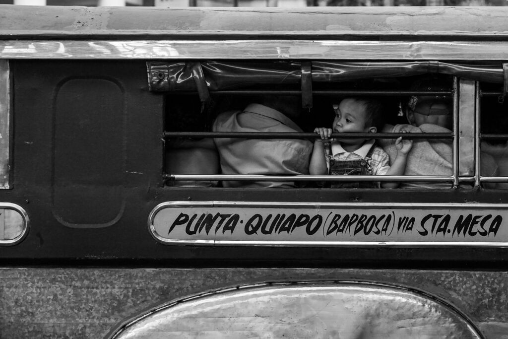 A child looks out of a passenger Jeepney, noticeably not in their designated route, plying Pedro Gil St., Ermita, Manila. 9 July 2017.